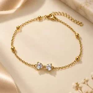 Aveline gold bow chain bracelet with clear stones and bead accents for women