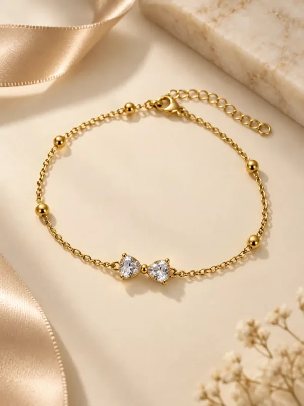 Aveline gold bow chain bracelet with clear stones and bead accents for women