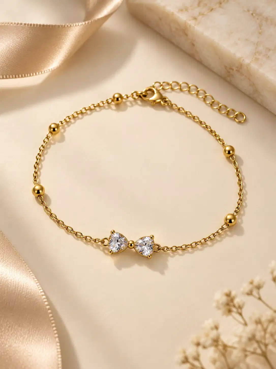 Aveline gold bow chain bracelet with clear stones and bead accents for women