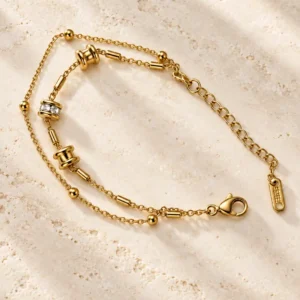Celeste gold double chain bracelet with barrel accents and clear stone detail